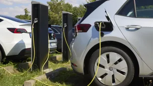 mehrere Ladestationen mit Elektrofahrzeugen, die gerade geladen werden